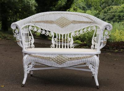 A cane two-seater sofa with