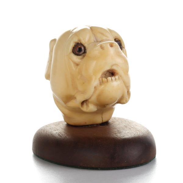 A CARVED IVORY GLASS-EYED DOG