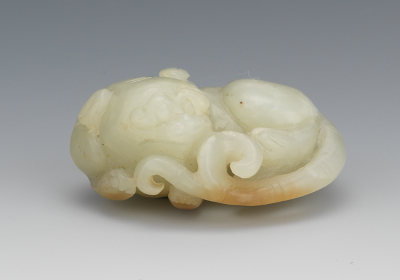 A Carved Jade Recumbent Baby Dragon