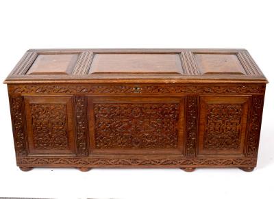 A carved oak chest with hinged