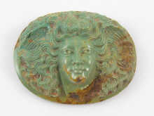 A carved oval turquoise cameo