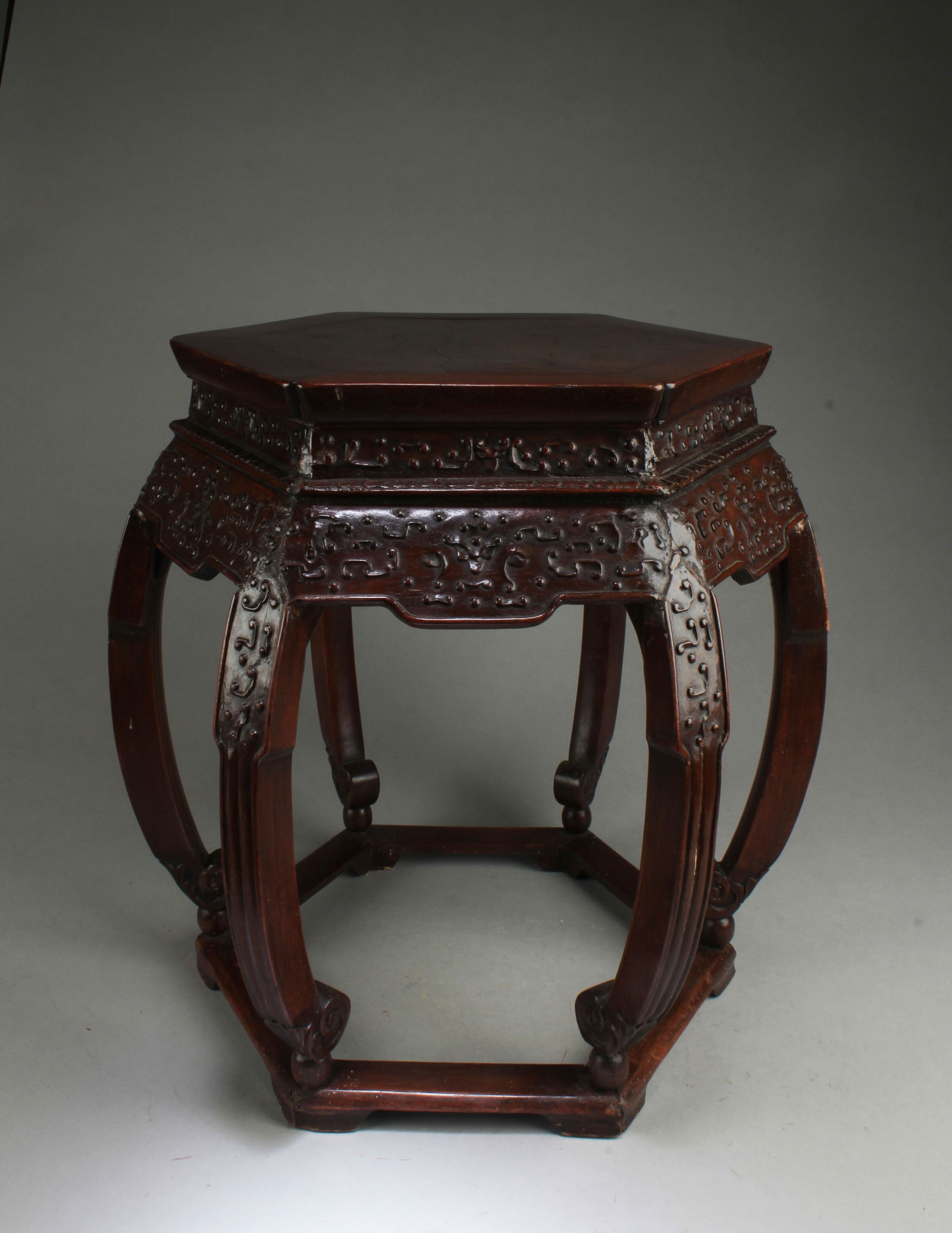 A CARVED WOODEN HEXAGONAL SHAPED