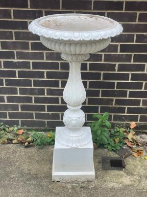 A cast iron bird bath on a baluster