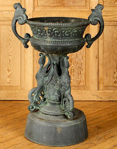 A CAST IRON URN WITH HERON
