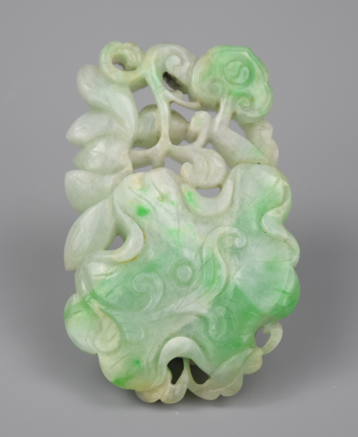 A CHINESE CARVED JADEITE PENDANT W/