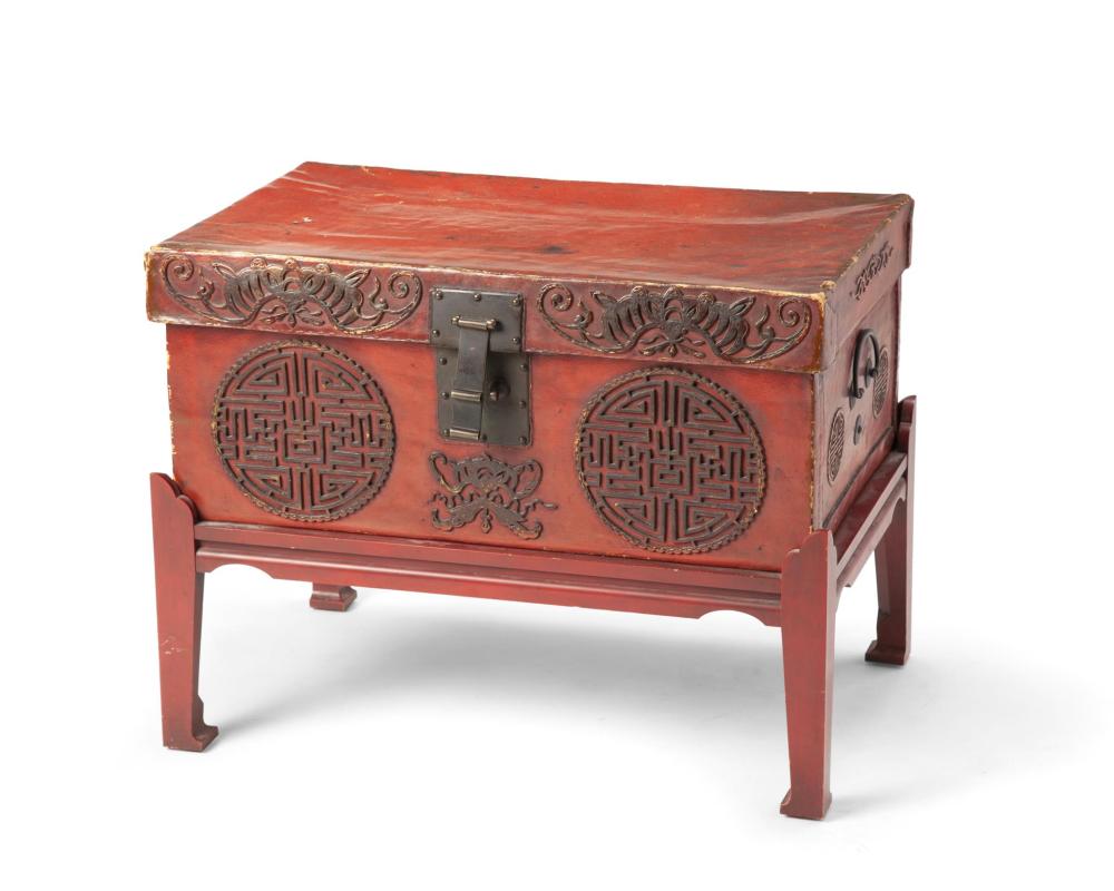 A CHINESE LEATHER CHEST ON A WOOD