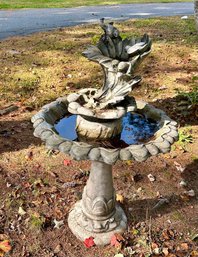 A concrete bird bath with bird