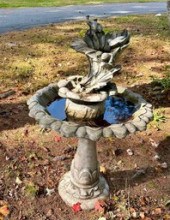 A concrete bird bath with bird
