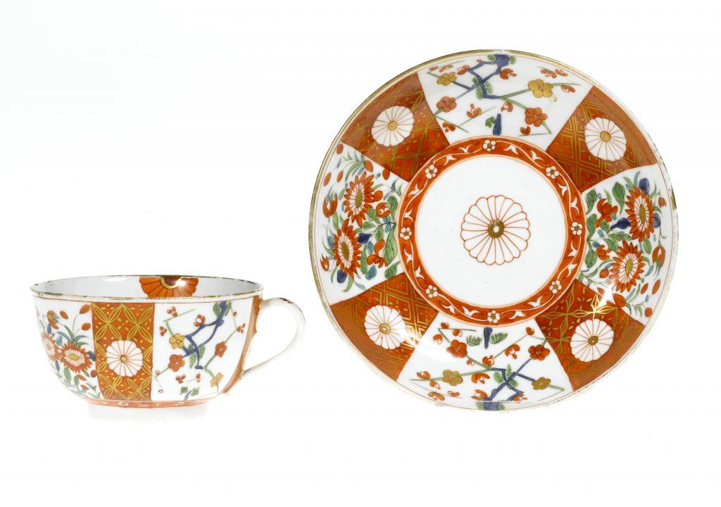 A DERBY TEACUP AND SAUCER enamelled