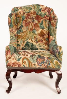 A doll's wing back armchair on