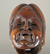 A FINE WOOD NETSUKE<br>Okame t
