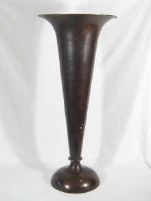 A floor standing brass trumpet vase