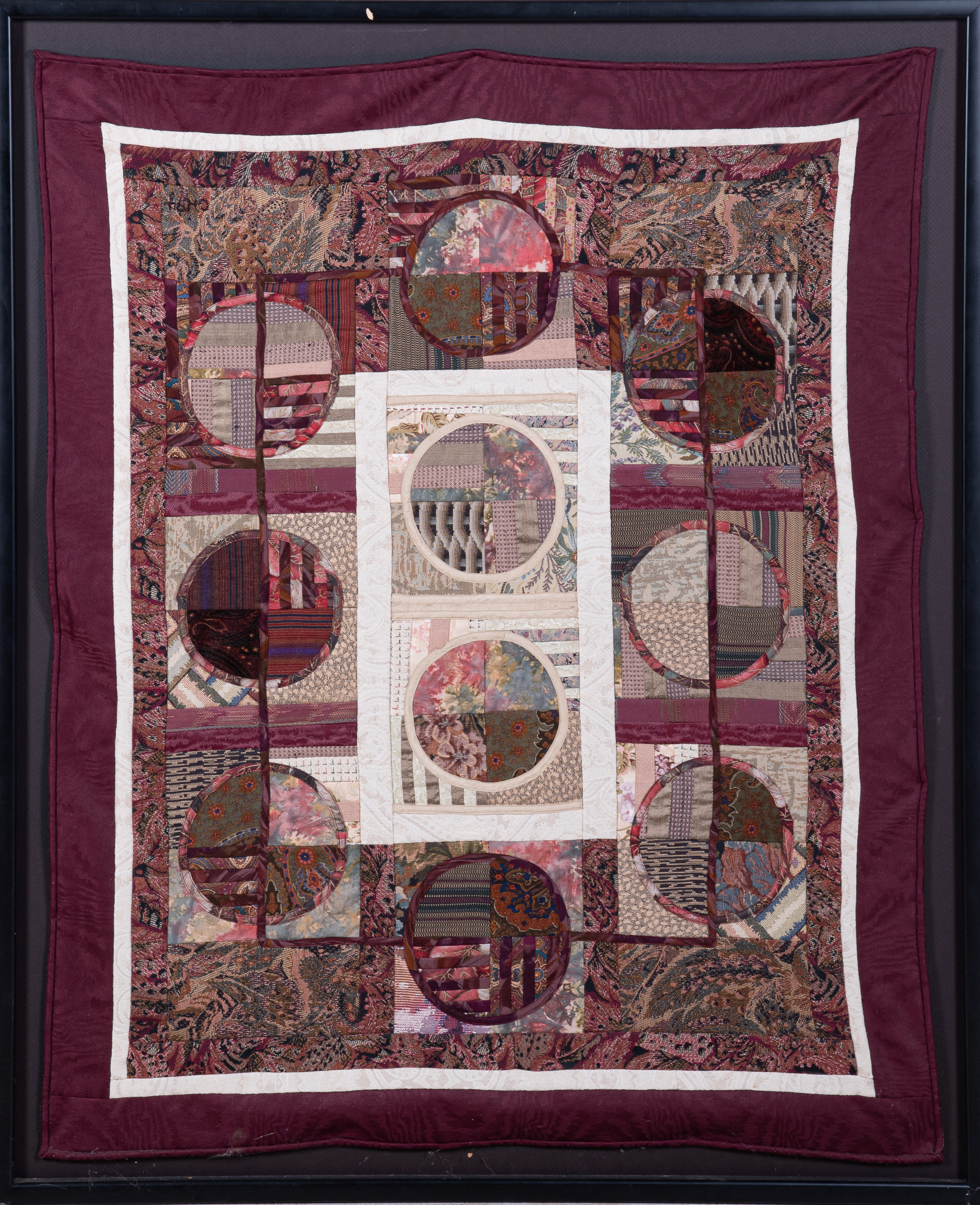 A framed hand pieced quilt,