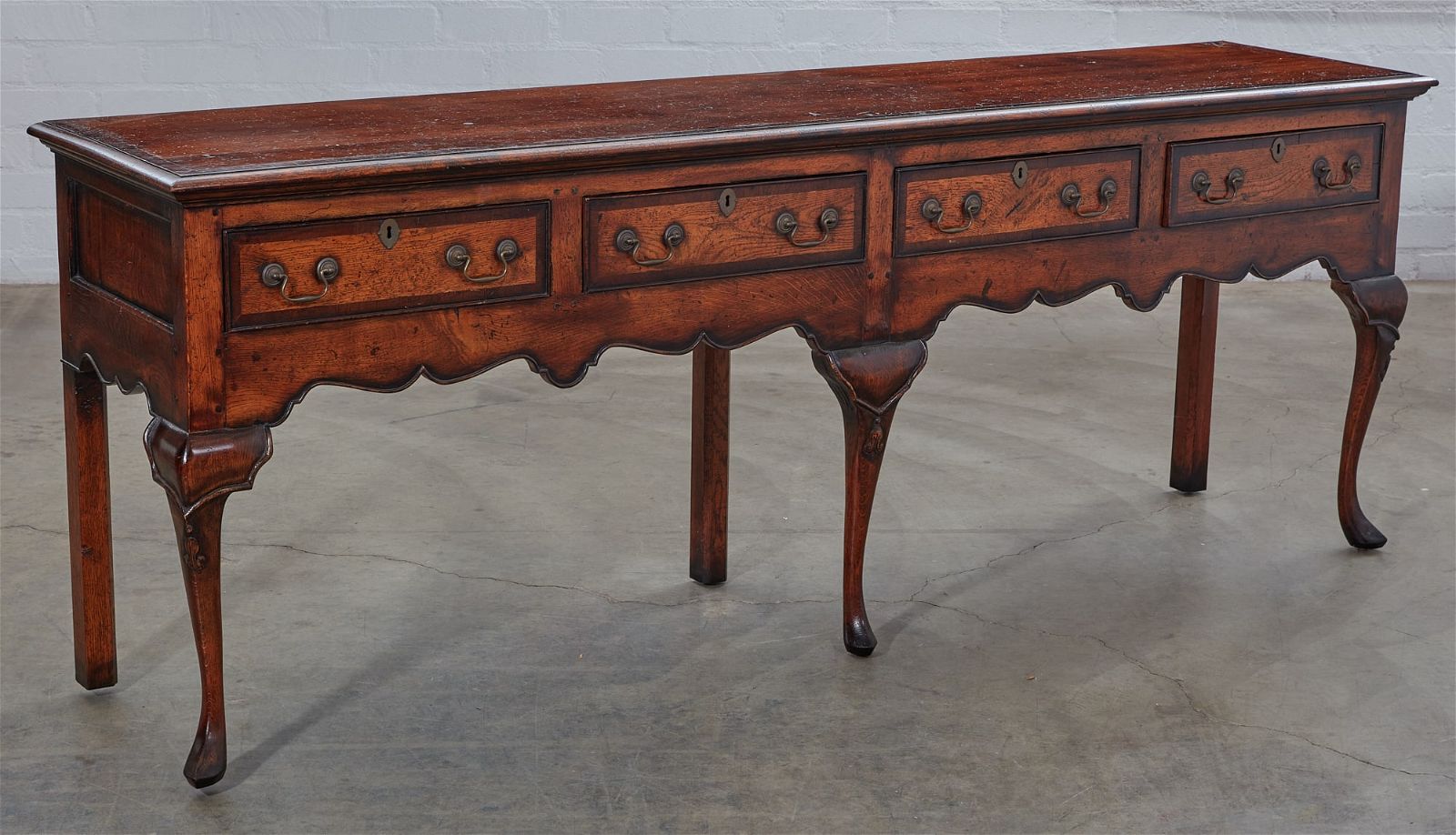 A GEORGE III STYLE OAK LOW DRESSER,