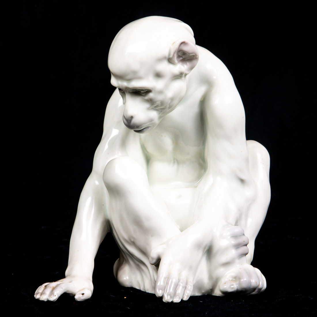 A GERMAN PORCELAIN FIGURE OF SEATED