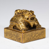 A GILDED BRONZE SEAL WITH DRAG
