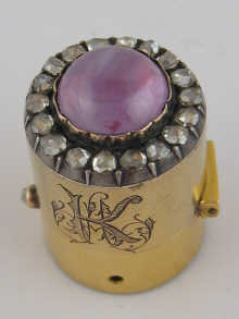 A gold scent bottle top with