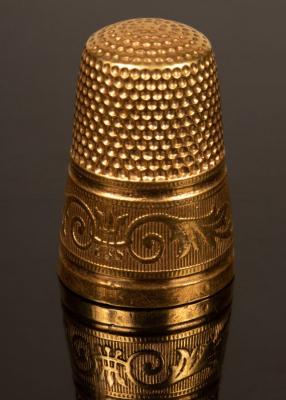A gold thimble with engraved