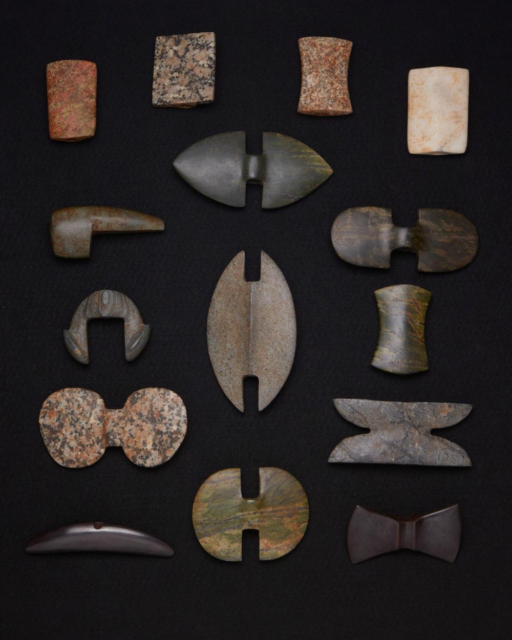 A GROUP OF CARVED STONE ATLATL