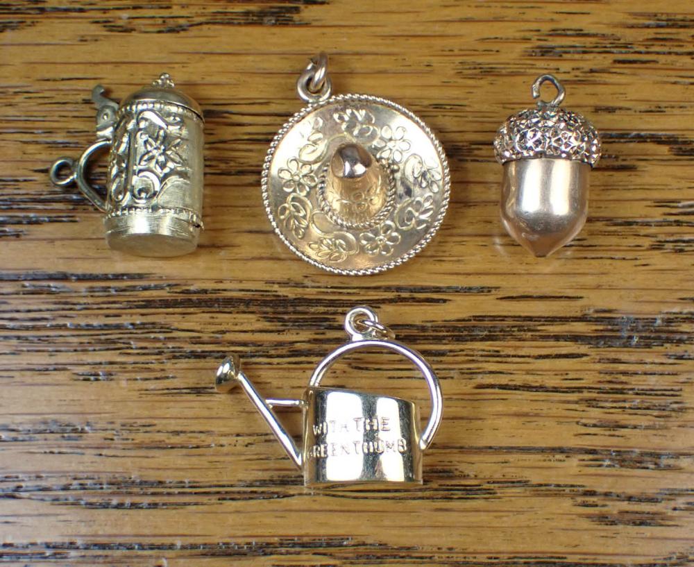 A GROUP OF FOUR GOLD CHARMSA