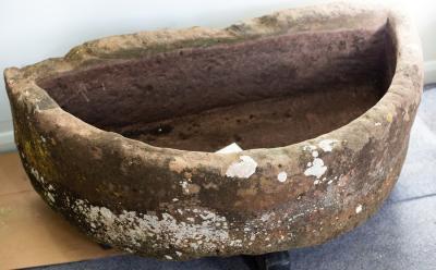 A large D-shaped stone trough,