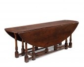 A LARGE OAK DROP-LEAF GATE LEG
