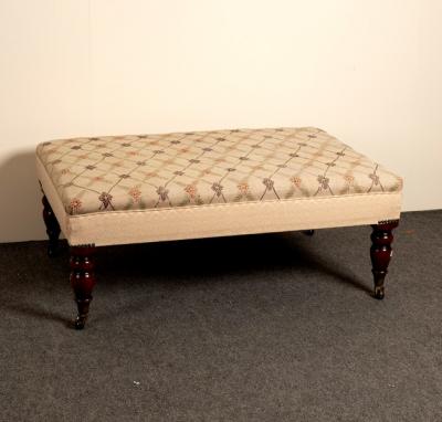 A low upholstered stool on turned