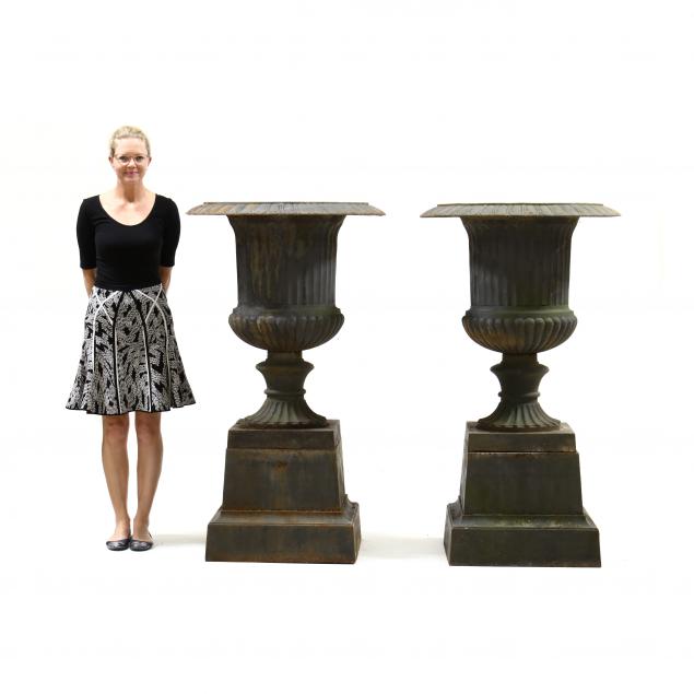 A MASSIVE PAIR OF CAST IRON URNS ON