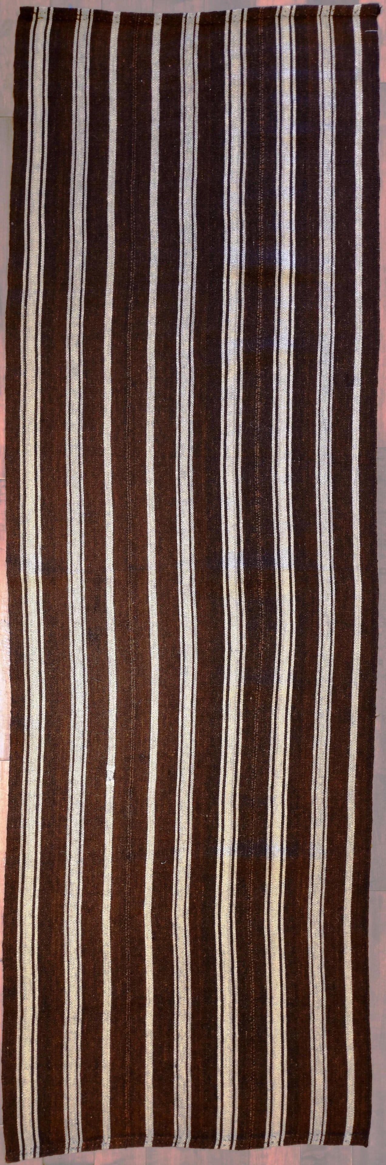 A NOMADIC FLATWEAVE CARPET,