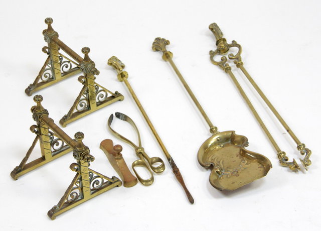A pair of brass fire dogs and a set