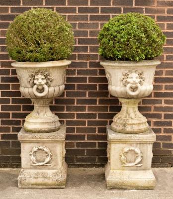 A pair of composition stone urns