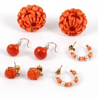 A pair of coral ear clips, carved