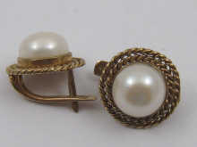 A pair of pearl earrings set in