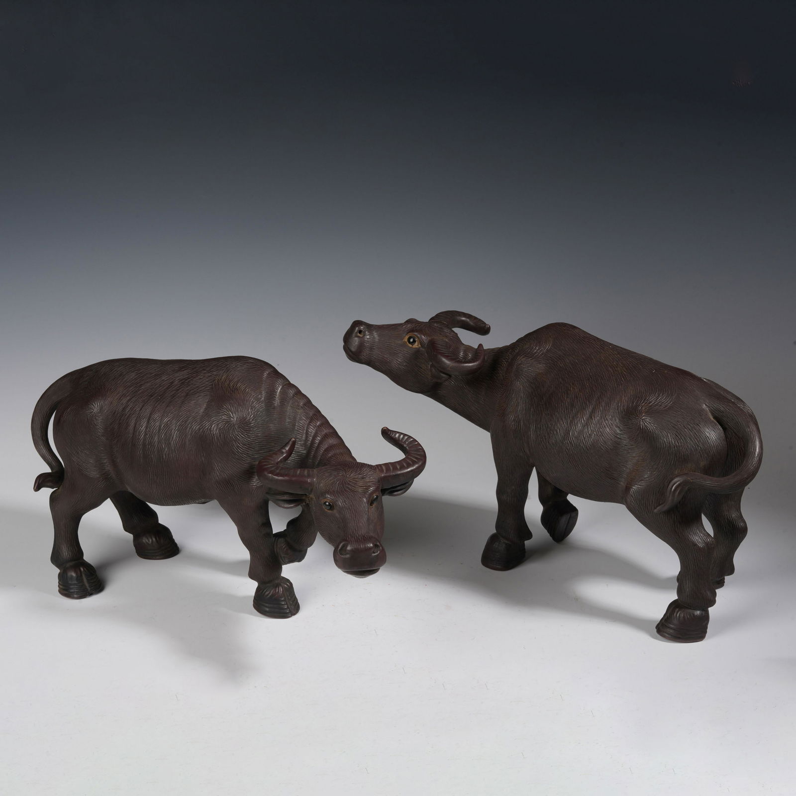 A PAIR OF ZISHA CLAY CATTLE