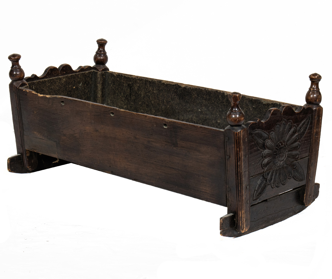 A PRIMITIVE CARVED CRADLE A