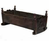 A PRIMITIVE CARVED CRADLE A Pr