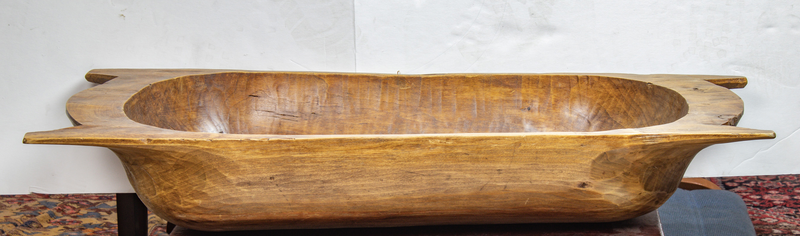 A PRIMITIVE CARVED WOOD TROUGH A