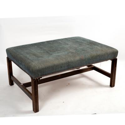 A rectangular and upholstered stool