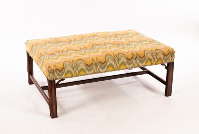 A rectangular upholstered footstool