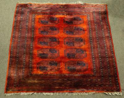 A red Bokhara rug with blue details