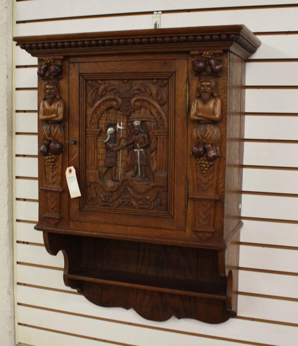 A RELIEF-CARVED OAK WALL CABINETA