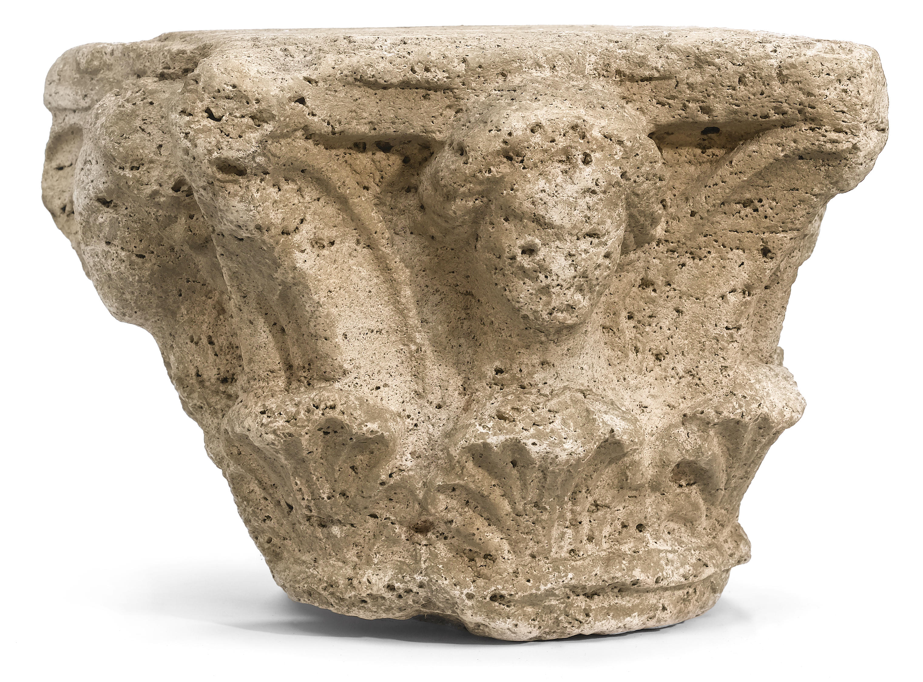 A Romanesque carved stone capital .