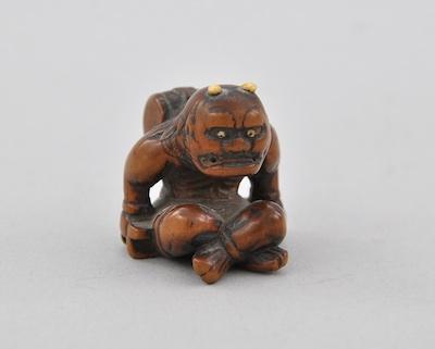 A Seated Oni Netsuke Carved wood