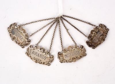 A set of four silver spirit labels,
