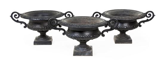 A Set of Three Cast Iron Urns of