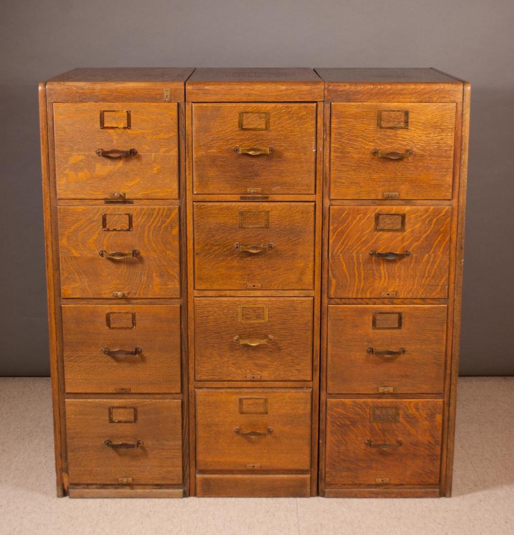 A SET OF THREE OAK FOUR-DRAWER FILE