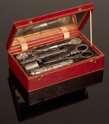A sewing kit in a red leather