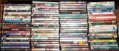 A SHELF OF ASSORTED DVDS Compr