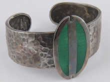 A silver and enamel bangle the oval