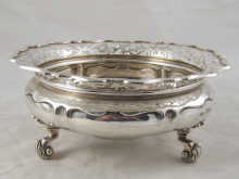 A silver bowl on three leaf